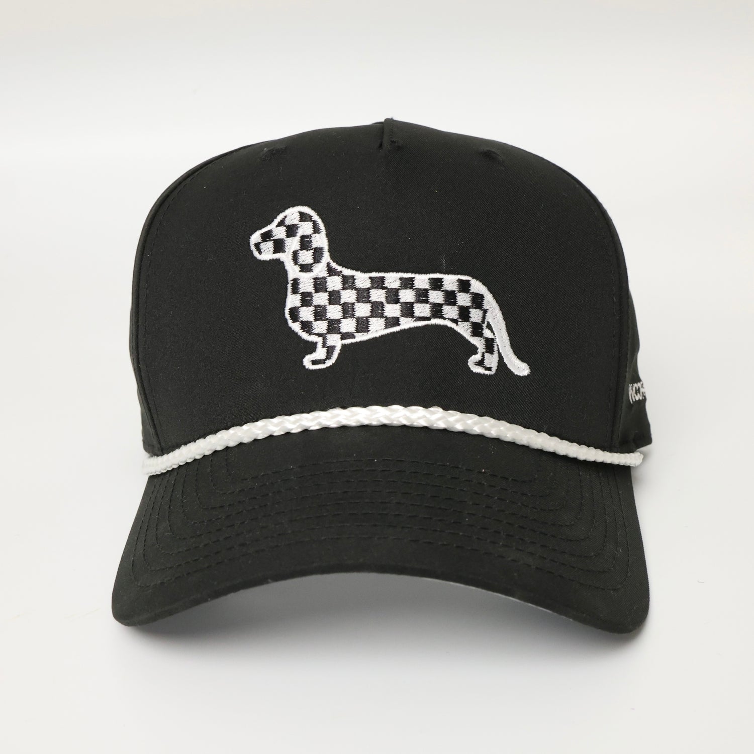 Black and white checkered dachshund embroidered on a black hat with white rope