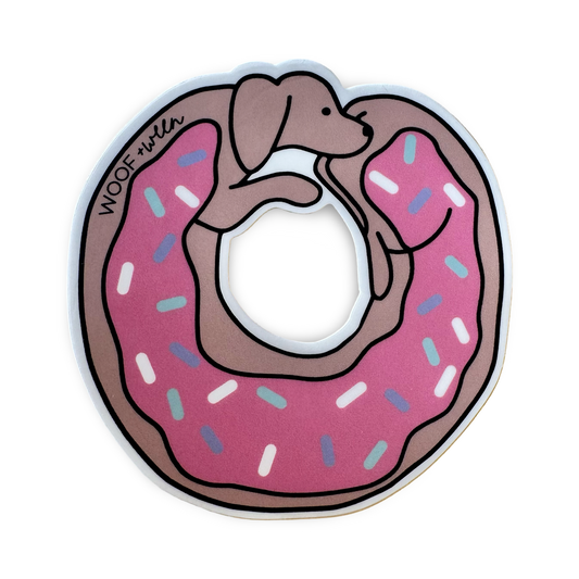 A die-cut sticker in the shape of a dachshund donut with pink frosting with white, blue, and purple sprinkles.