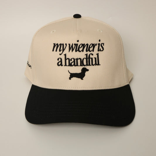 Beige and black dachshund hat with text 'my wiener is a handful'