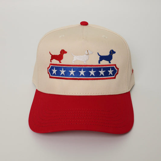 Cap with embroidered dogs and stars design on a beige and red background