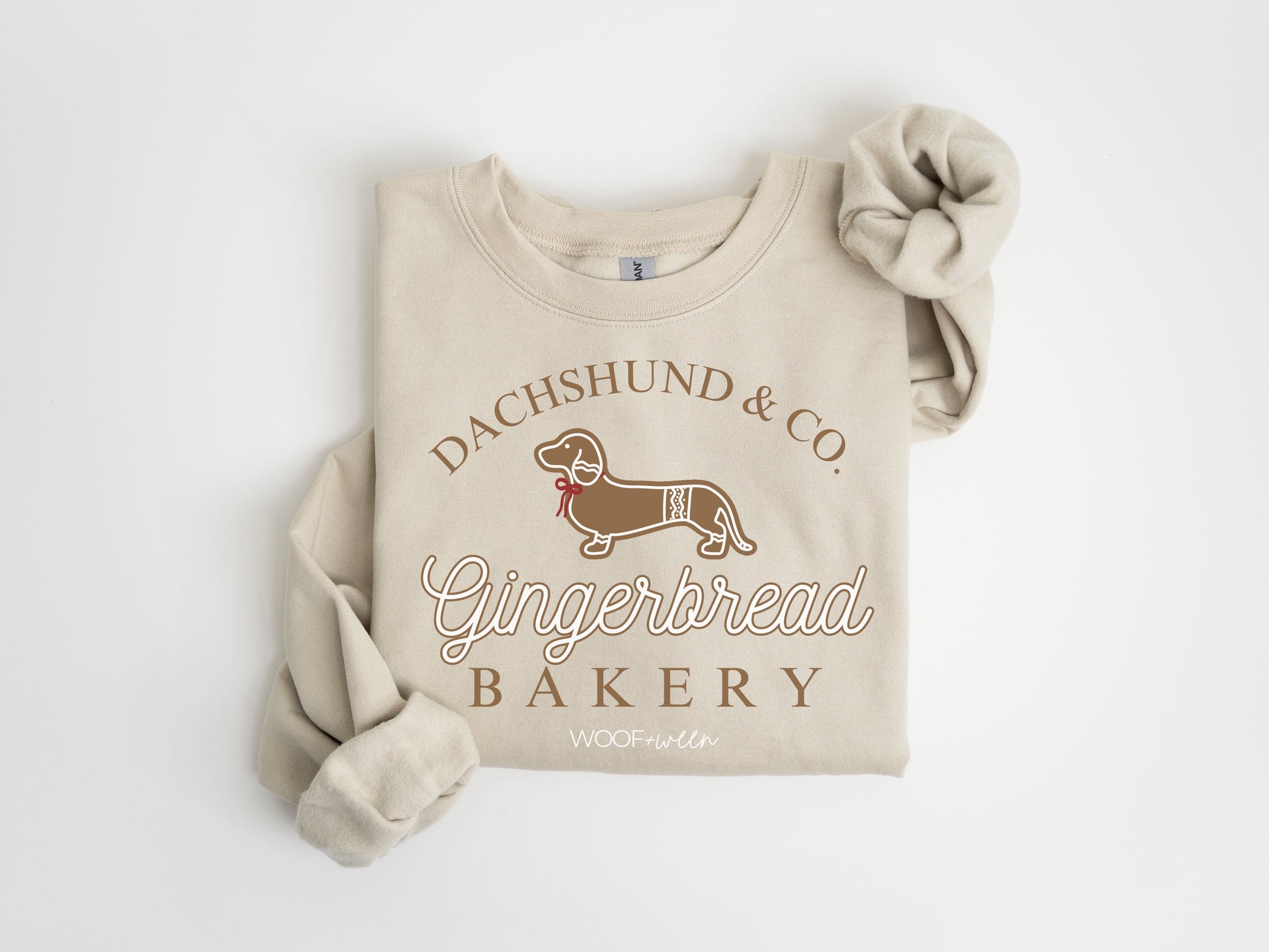 A tan sweatshirt with a dachshund gingerbread Christmas design