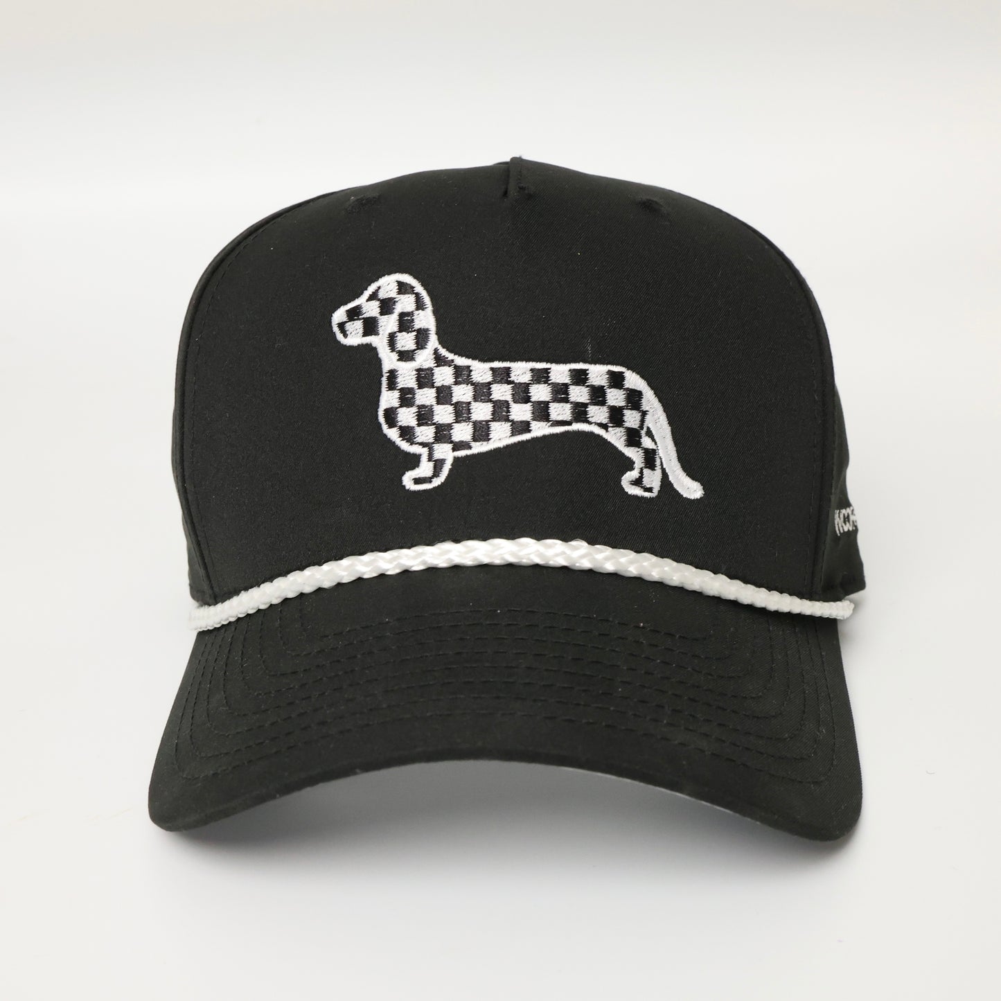 Black and white checkered dachshund embroidered on a black hat with white rope