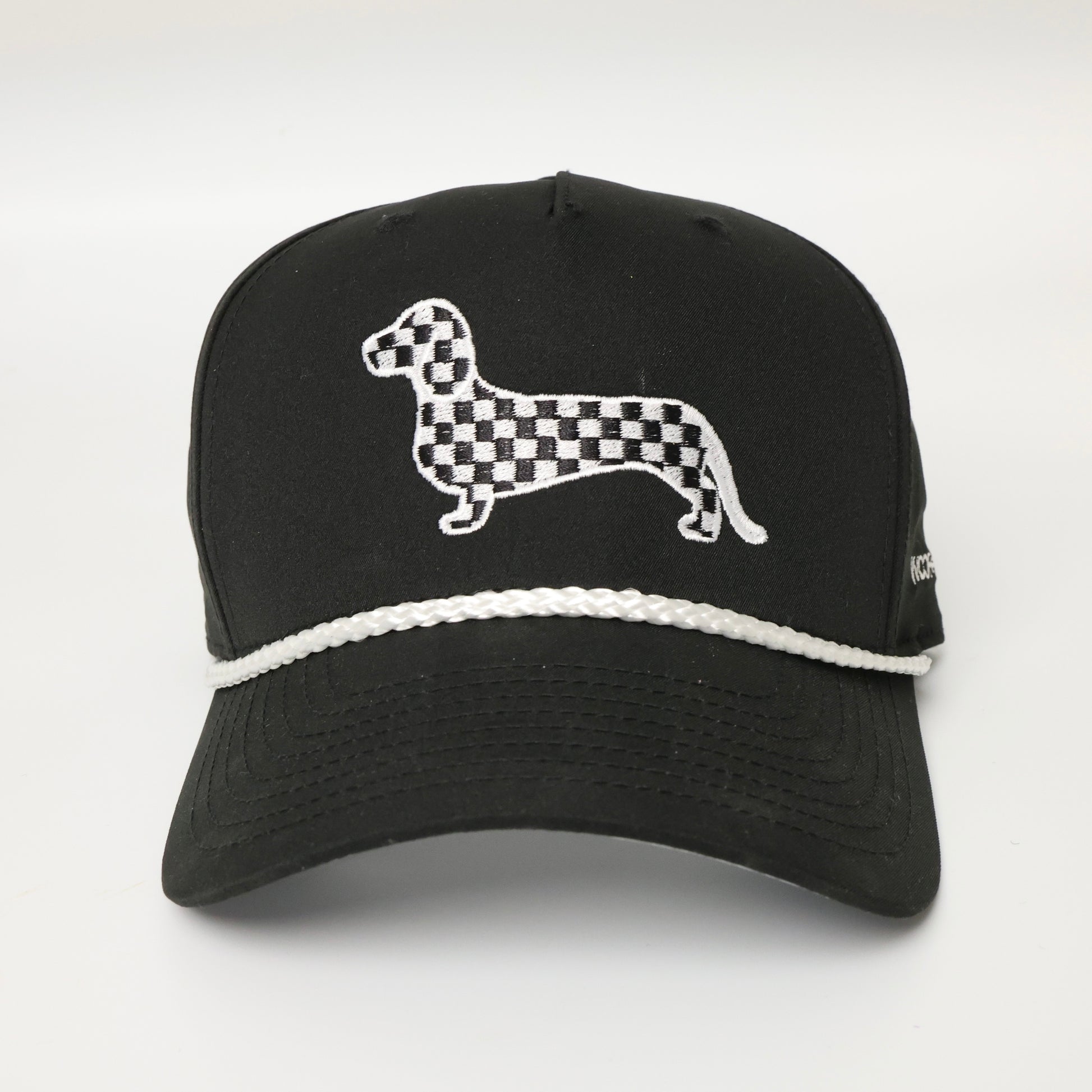 Black and white checkered dachshund embroidered on a black hat with white rope