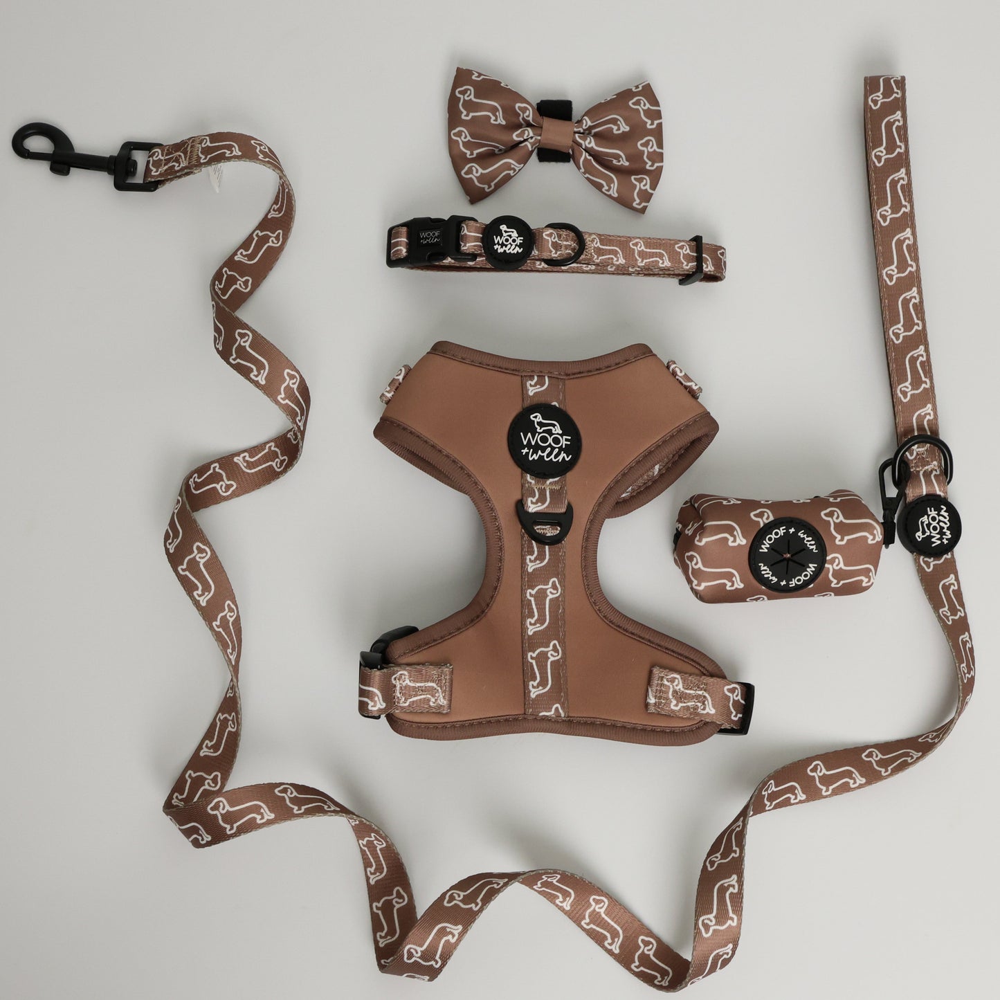 Tan dog harness with dachshunds on it with a matching leash and collar