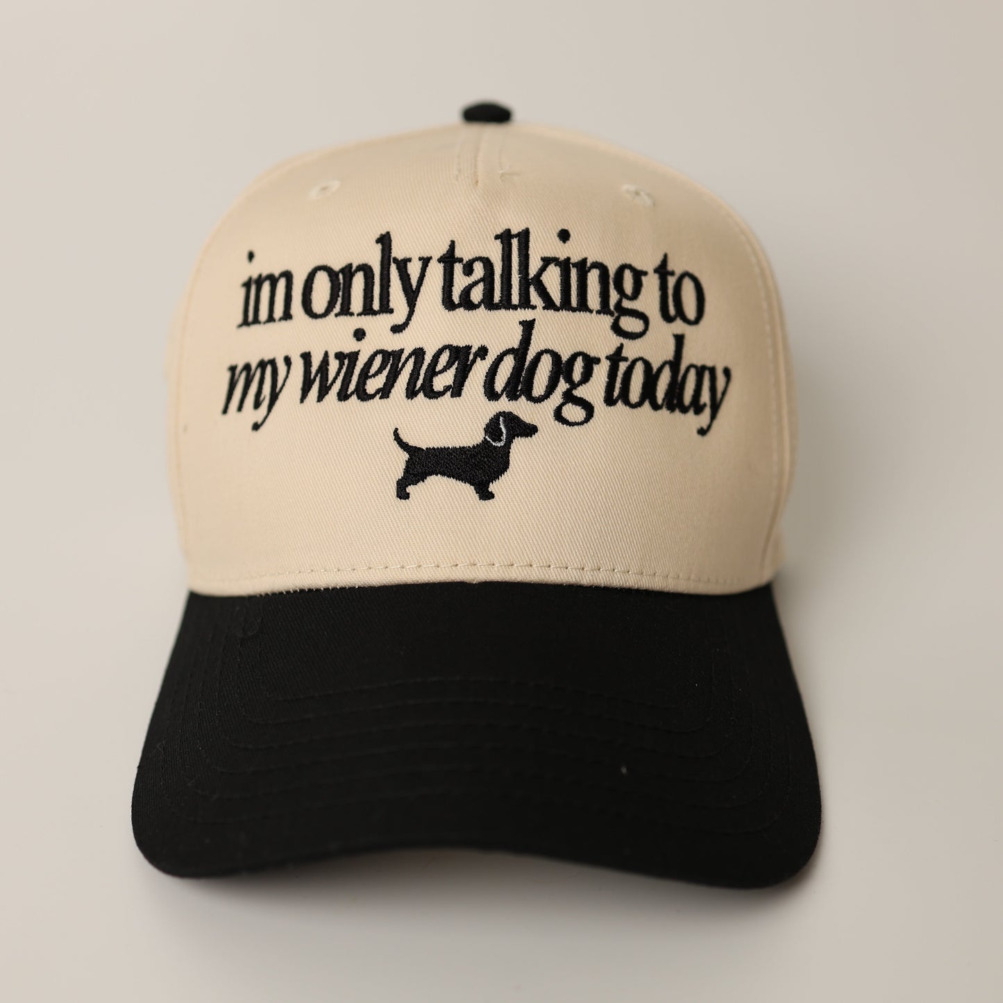 Dachshund Hat with text 'I'm only talking to my wiener dog today' on a beige and black cap