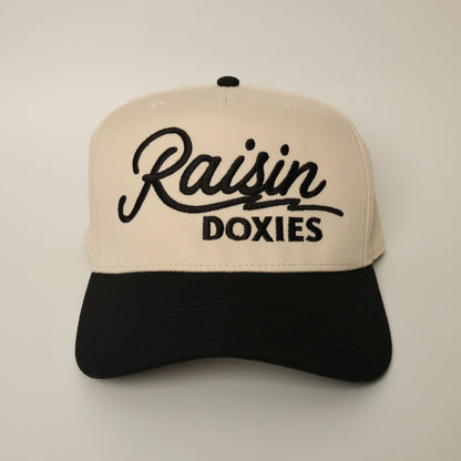 Beige and black dachshund hat with 'Raisin Doxies' text 