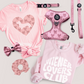 Collection of pink bow  pet accessories including a t-shirt, harness, and bow on a light background