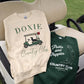 Two sweatshirts with 'Doxie Country Club' and 'Putts and Puppies Country Club' designs on a golf cart seat.