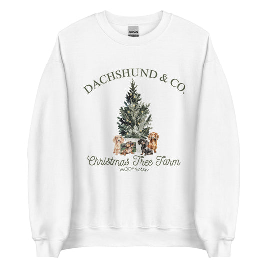 A white crewneck sweatshirt with a vintage Christmas Tree design with dachshunds on it